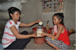 Mẹ con chị Đoàn Thị Hòe góp gạo vào hũ gạo tình thương mỗi ngày