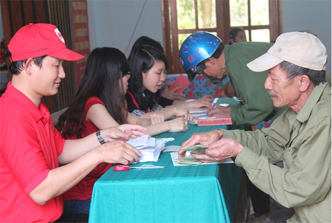 Cán bộ Hội Chữ thập đỏ tỉnh, huyện và tình nguyện viên đối chiếu hồ sơ cấp tiền cho các hộ hưởng lợi.