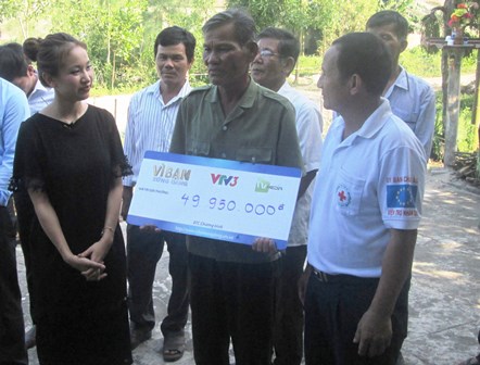 Ông Mai Văn Kiệm (đứng giữa) xúc động khi đón nhận phần quà từ Chương trình