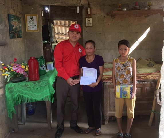 Ông Nguyễn Hữu Luật - Chủ tịch Hội CTĐ huyện Gio Linh trao tiền do các mạnh thường quân hỗ trợ cho gia đình anh Thảo