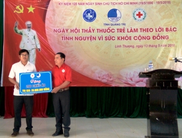 Ông Trần Thanh Hải - Phó Chủ tịch Hội Chữ thập đỏ tỉnh trao bảng tượng trưng tặng 200 chiếc áo phông cho bà con 02 xã Linh Thượng và Vĩnh Trường