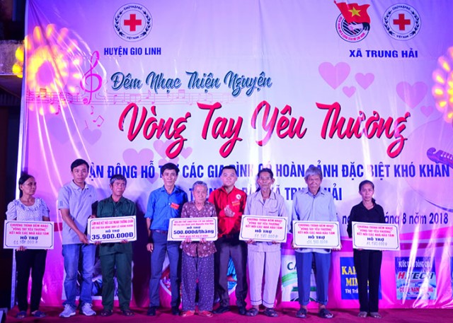 Ông Nguyễn Hữu Luật (áo đỏ) - Chủ tịch Hội CTĐ huyện Gio Linh trao biểu tượng trưng số tiền ủng hộ cho 06 hộ gia đình
